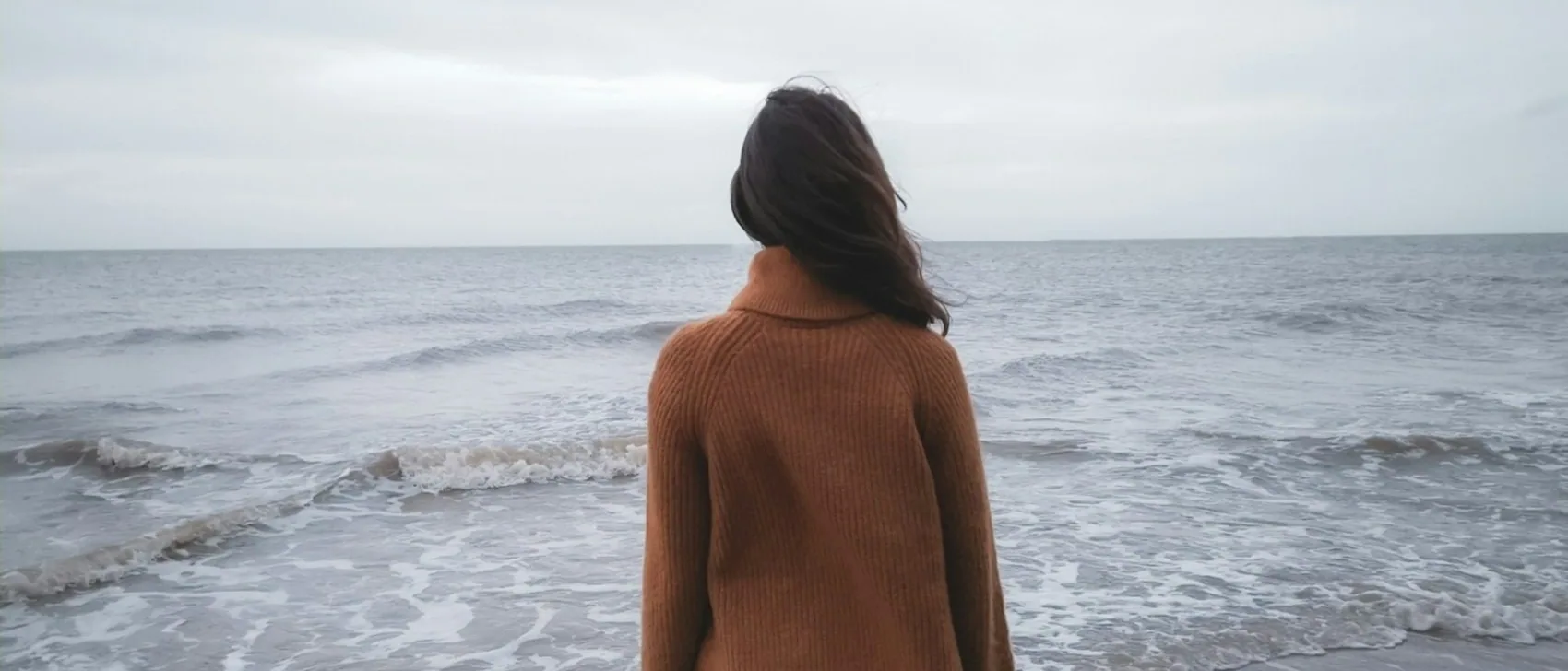 someone looking out to sea, from behind