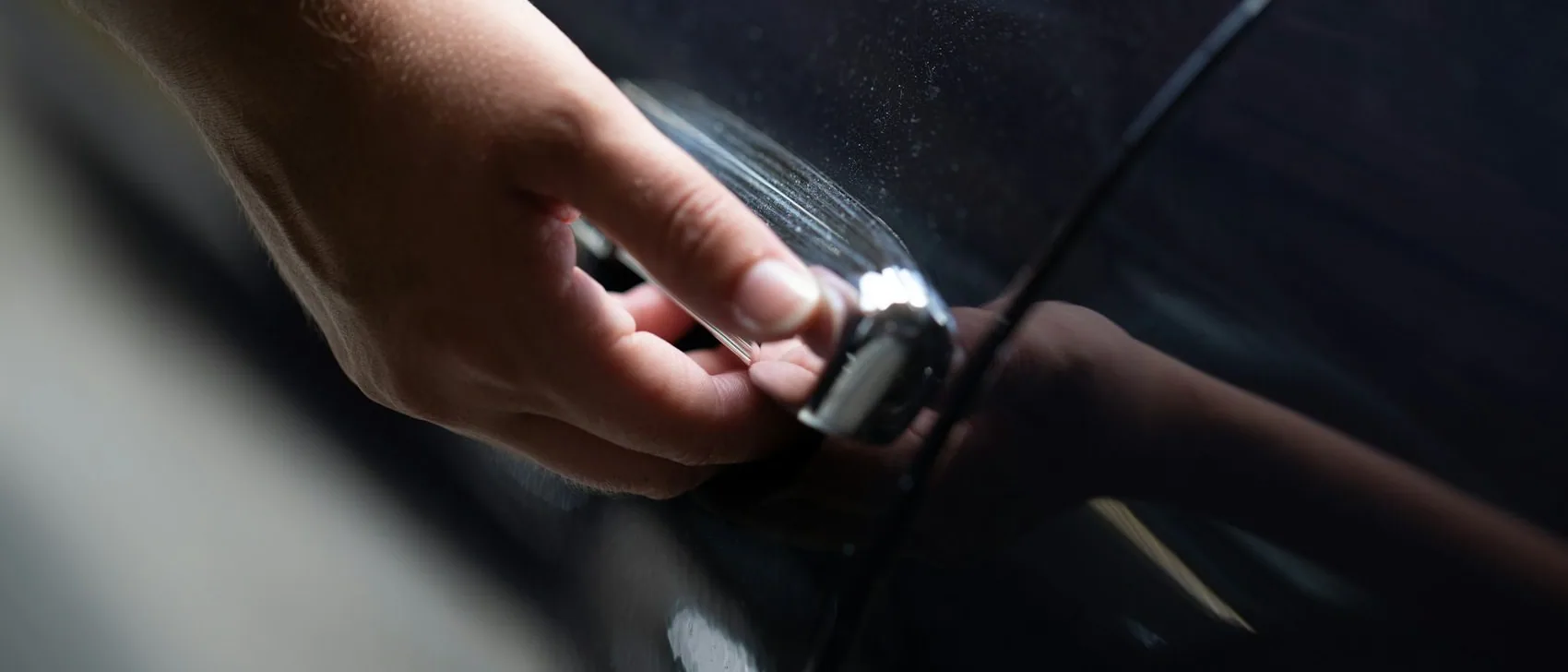 a hand on a car door handle