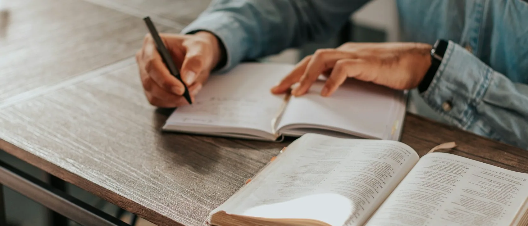hands writing in a notebook